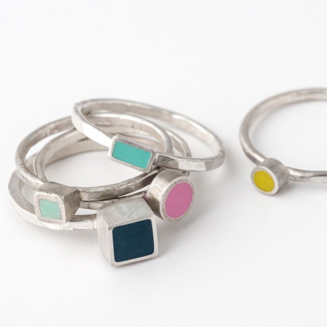 Several silver stacking rings with different shapes and colours