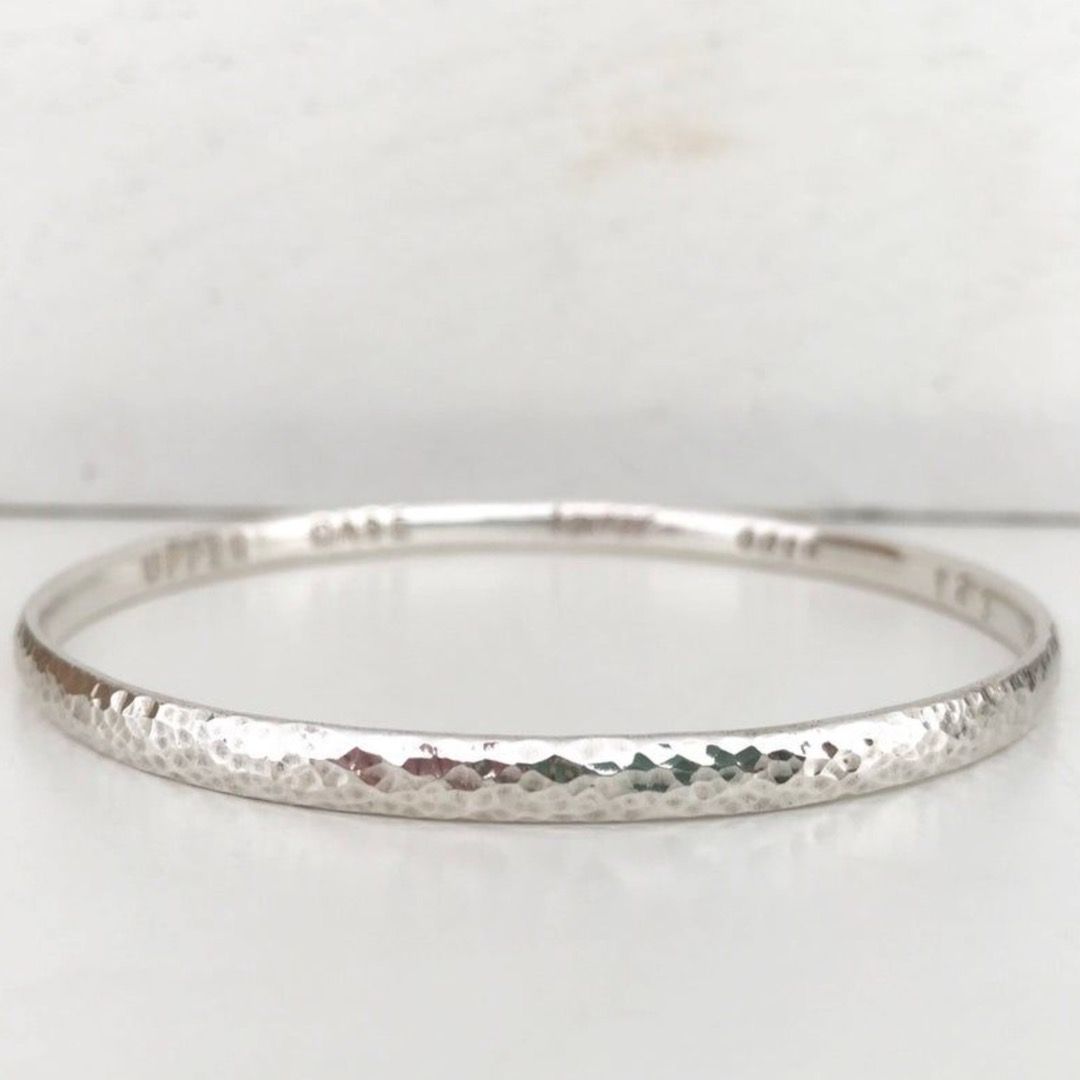A textured sterling silver bangle with a hammered finish