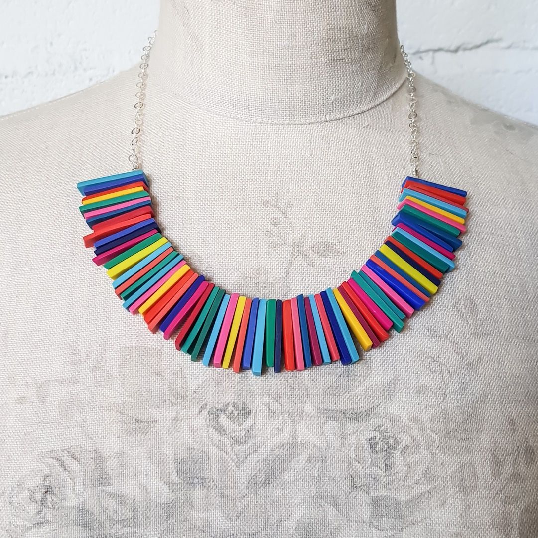 A necklace featuring  different coloured bars creating a rainbow effect