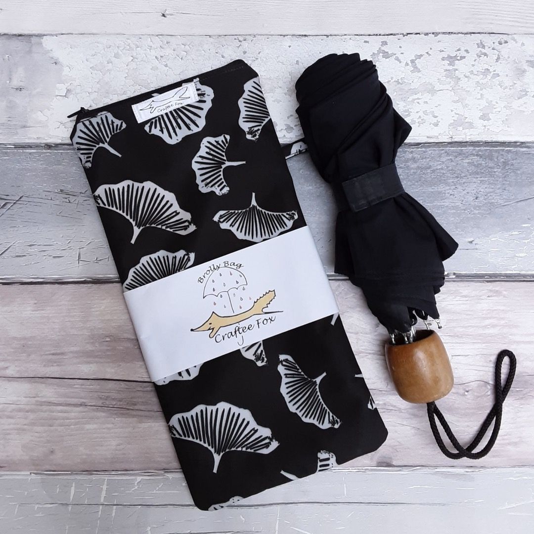 A black brolly and brolly back with a white mushroom pattern