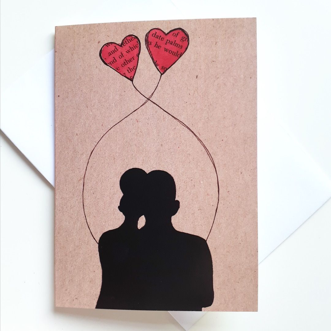 Brown card featuring the silhouette of a couple  with two hearts tethered above their heads