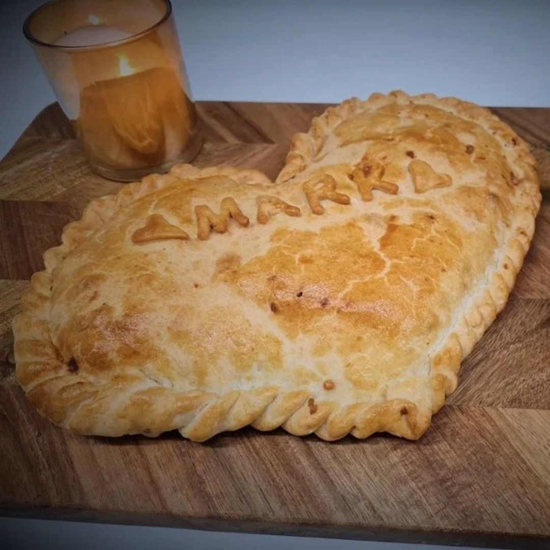 A heart shaped cornish pasty with mark written on the front