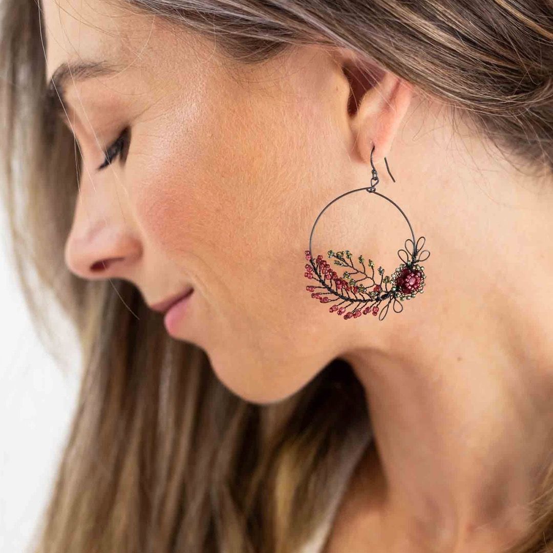 Hoop earring featuring a bunch of elegant foliage in deep red.