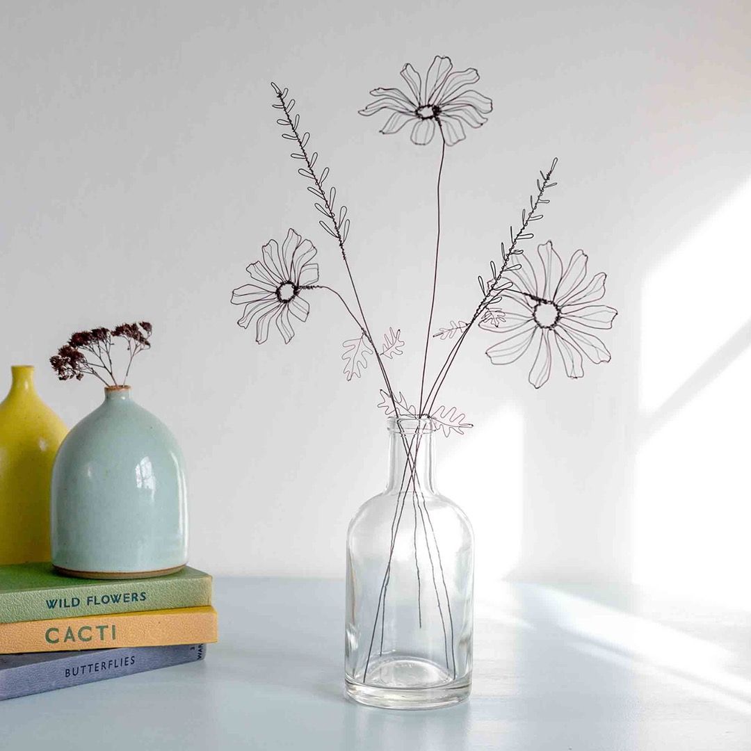a set of handcrafted wire ox eye daisies in a glass vase
