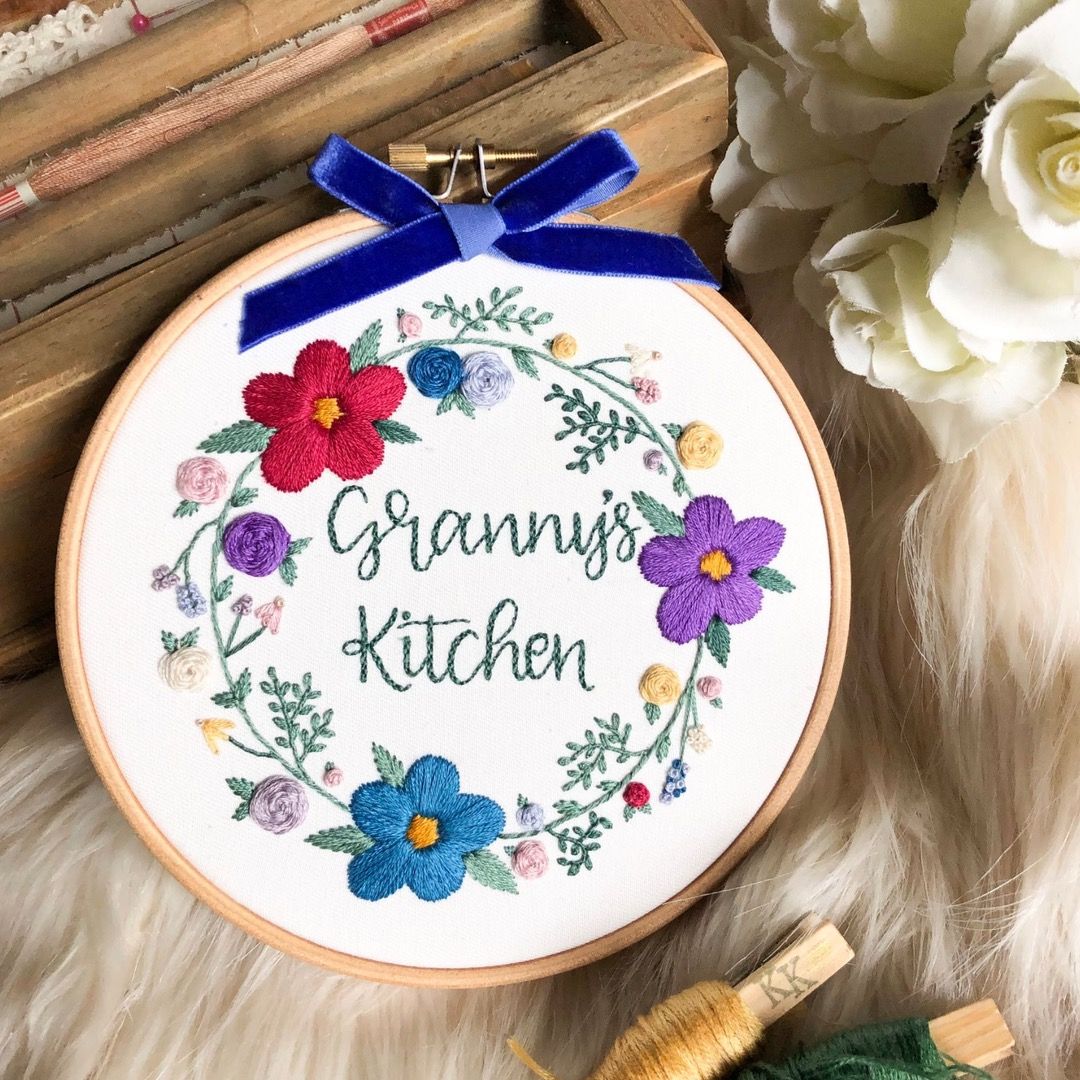 An embroidery hoop with a floral wreath design that says "Granny's Kitchen"