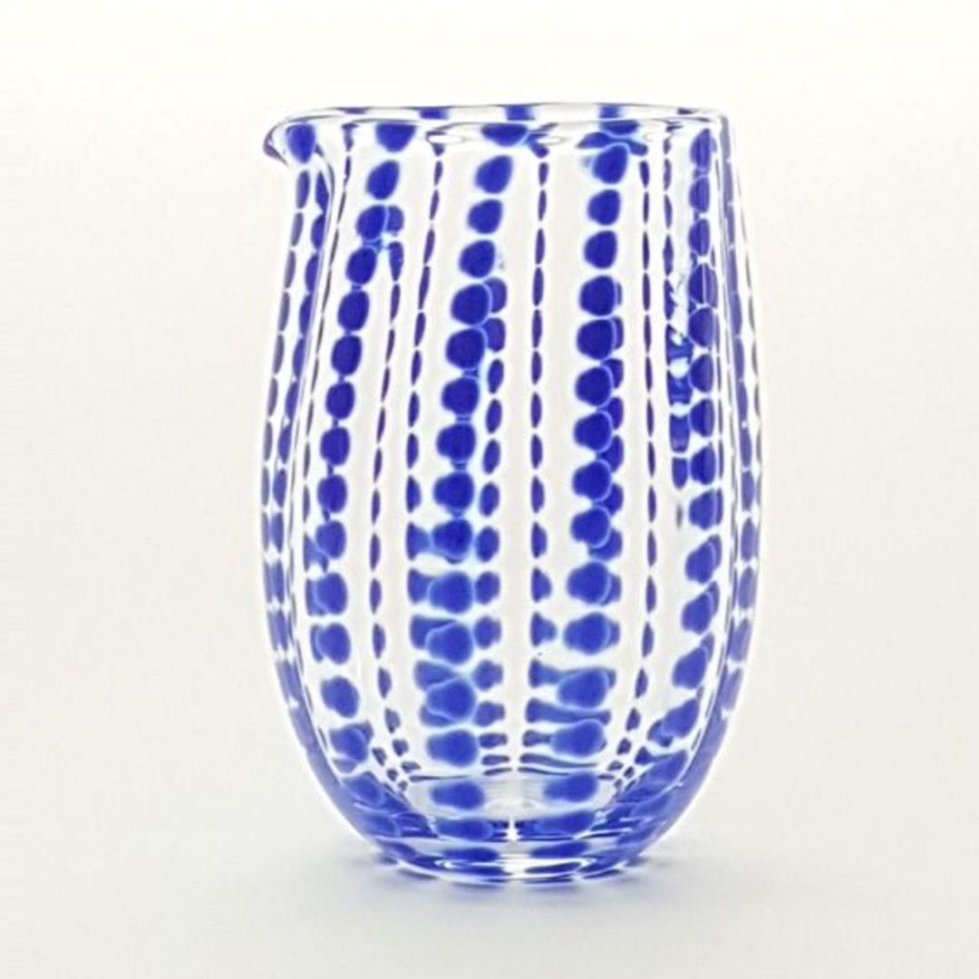 A mouth blown blue jug with blue spots up and down its body