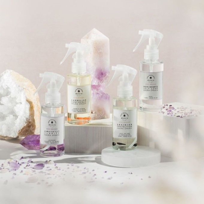 A selection of aura sprays and room mists around a gemstone display