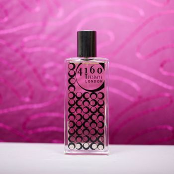 Rosa Ribes perfume against a deep pink wavy backdrop