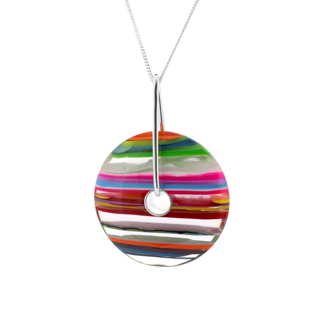 A multicoloured, polished circle pendant made from surfite on a dark brown leather necklace