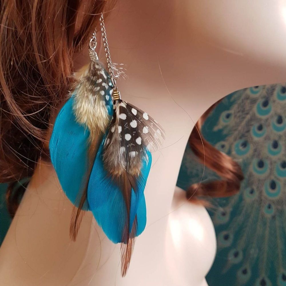 Two vibrant blue feathers with speckled down hanging earrings