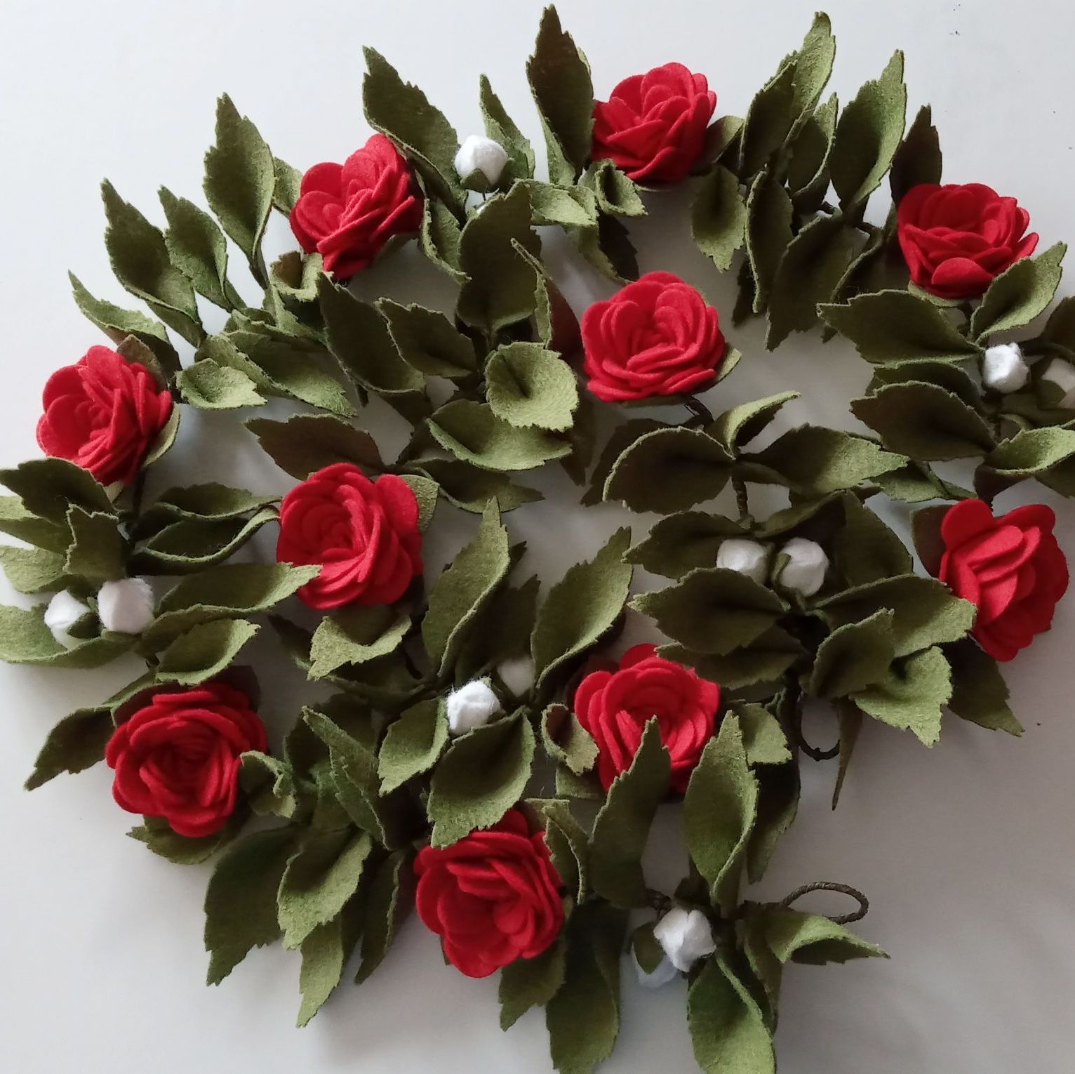 A garland of 10 felt red roses and foliage