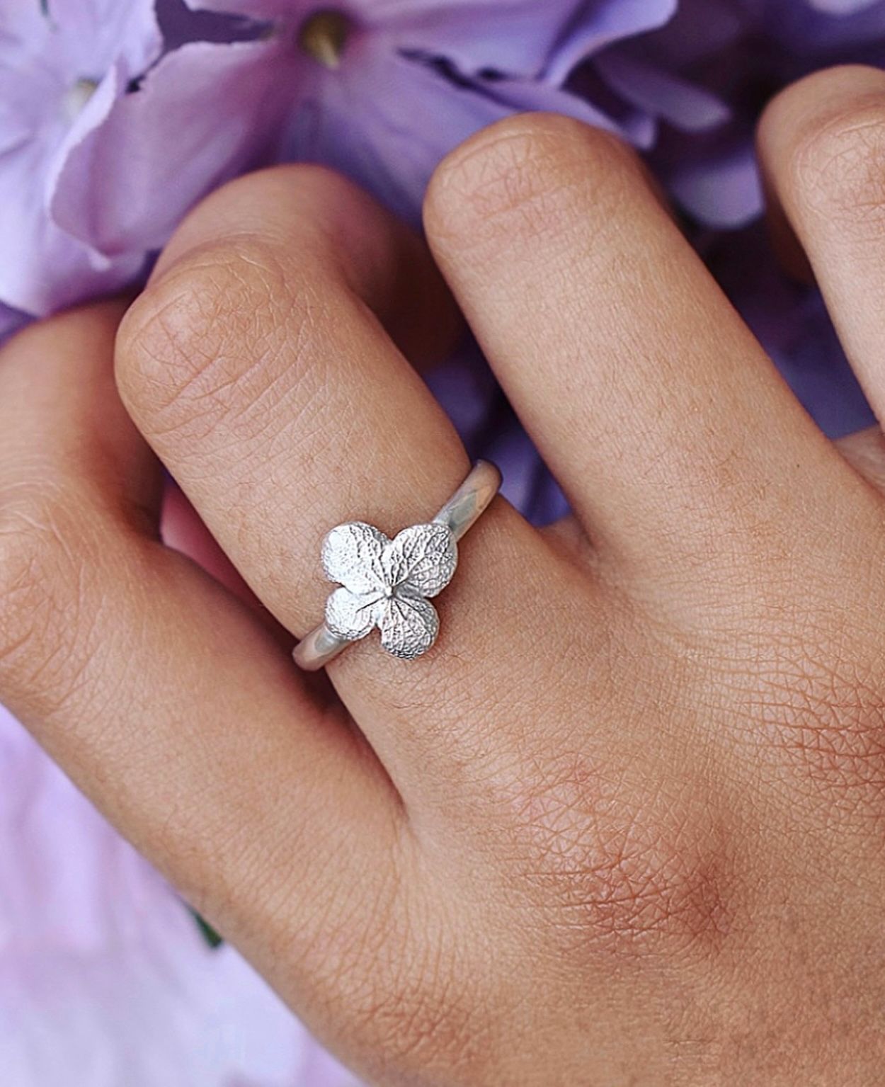 A dainty silver ring with a cast hydrangea flower