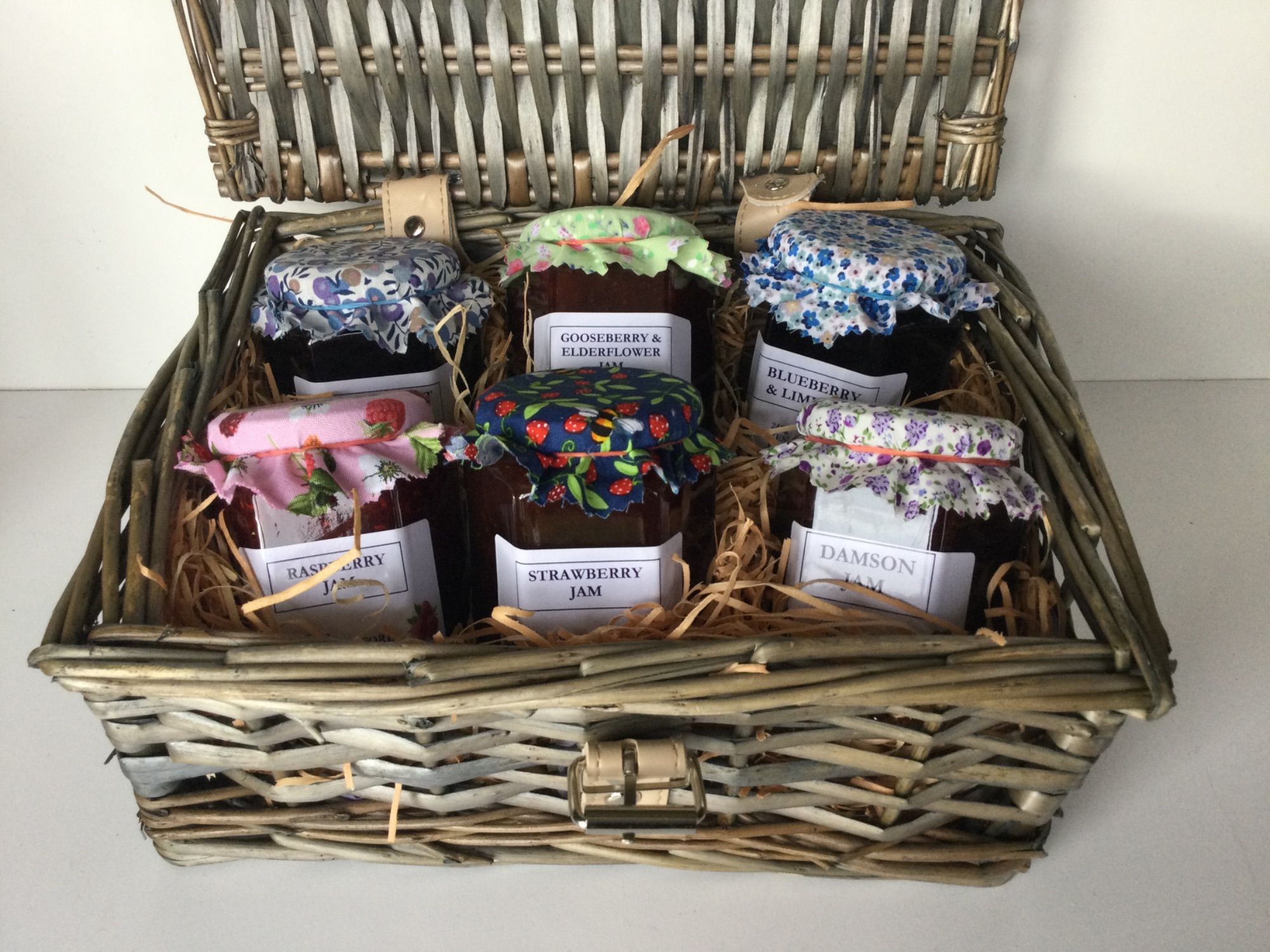 A wicker hamper containing six different jams