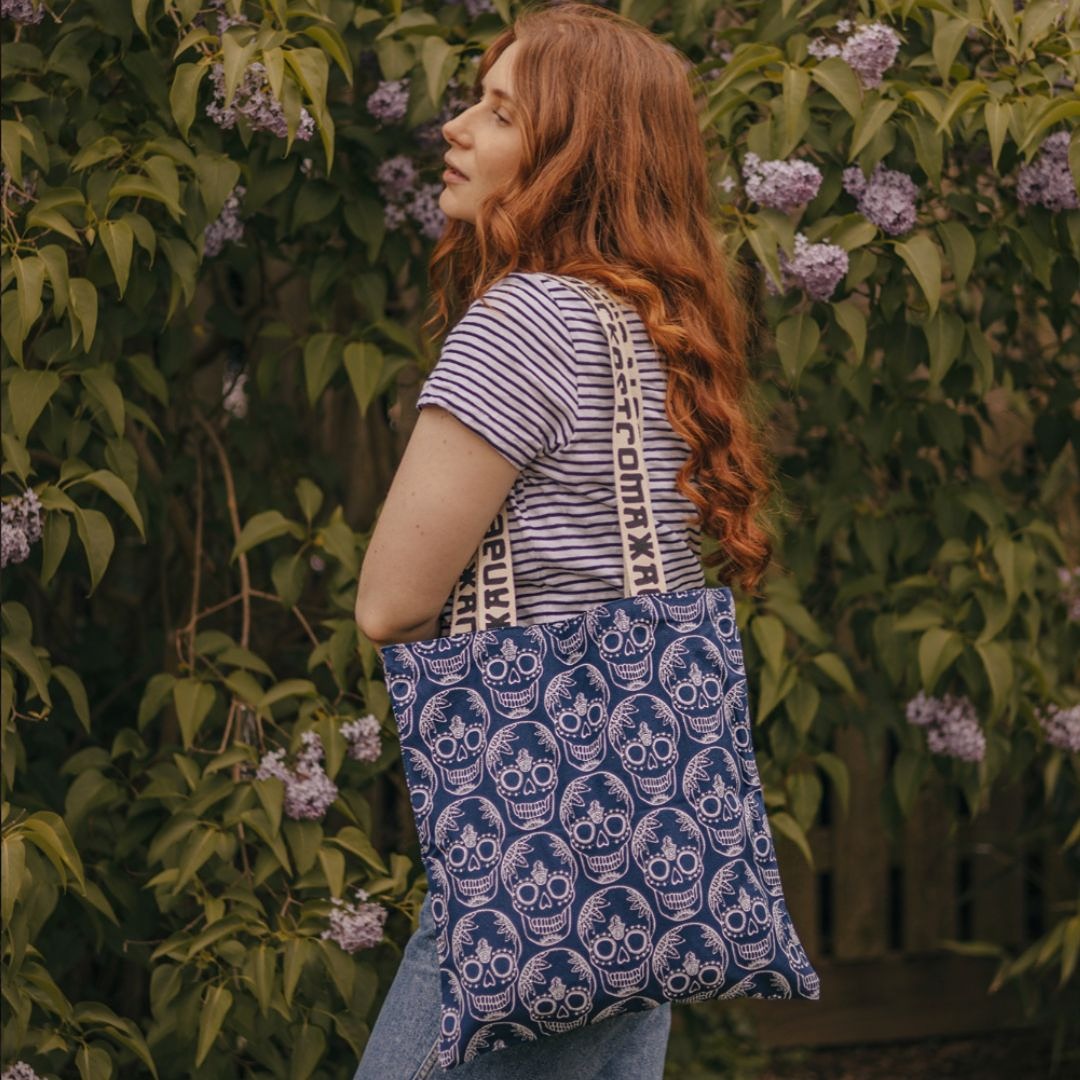 A person wearing a long white scarf with an abstract flower pattern