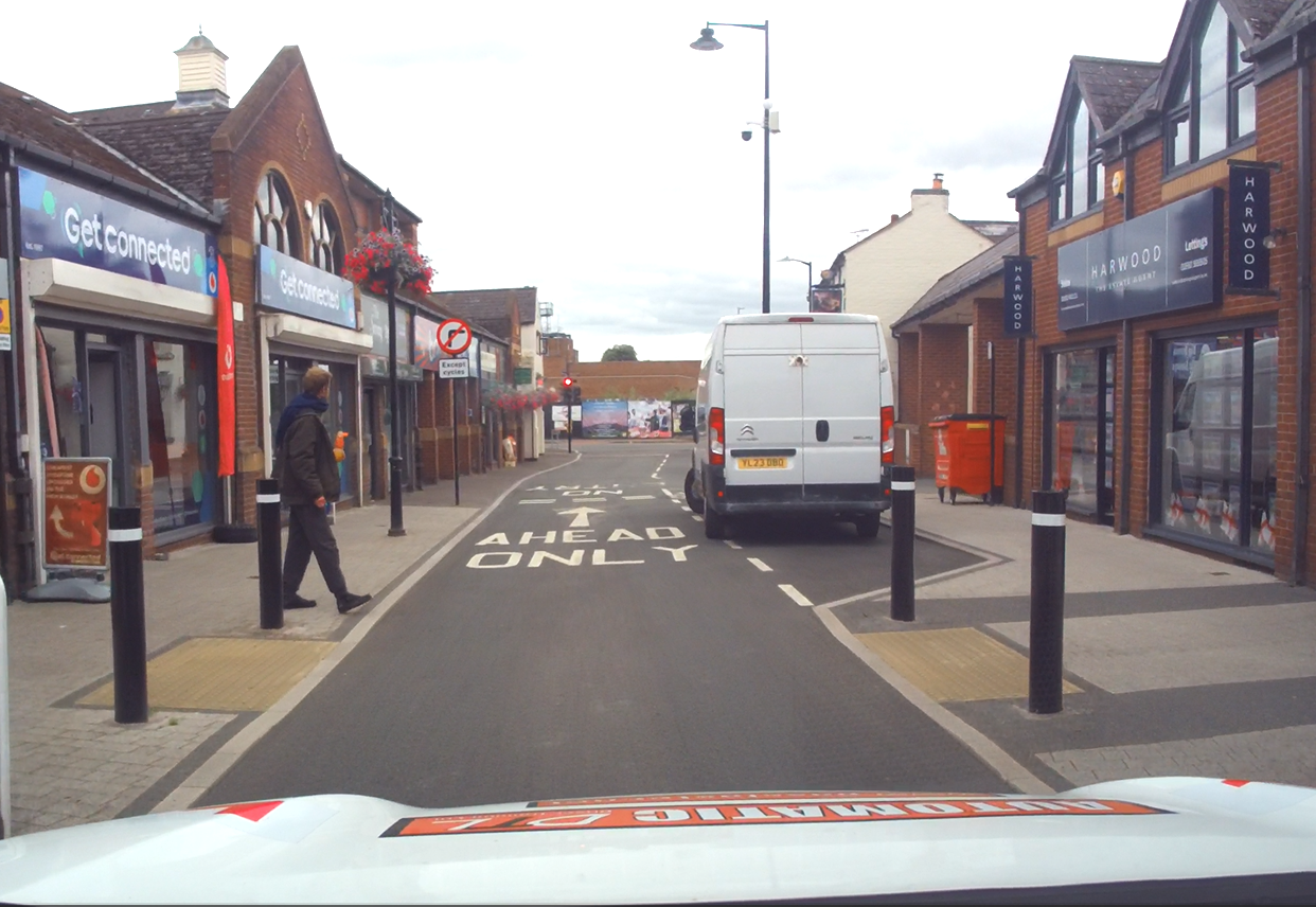 Crossing a residential street where there are no crossing markings. Crossing outside a school where there isn't a designated crossing. Crossing between parked cars. Crossing near a bus stop. Crossing a side road at a junction. Crossing a quiet country lane.