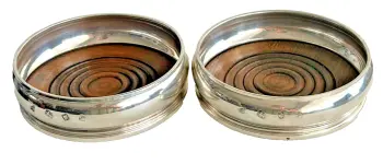 A pair of vintage sterling silver wine bottle coasters hallmarked London 1972