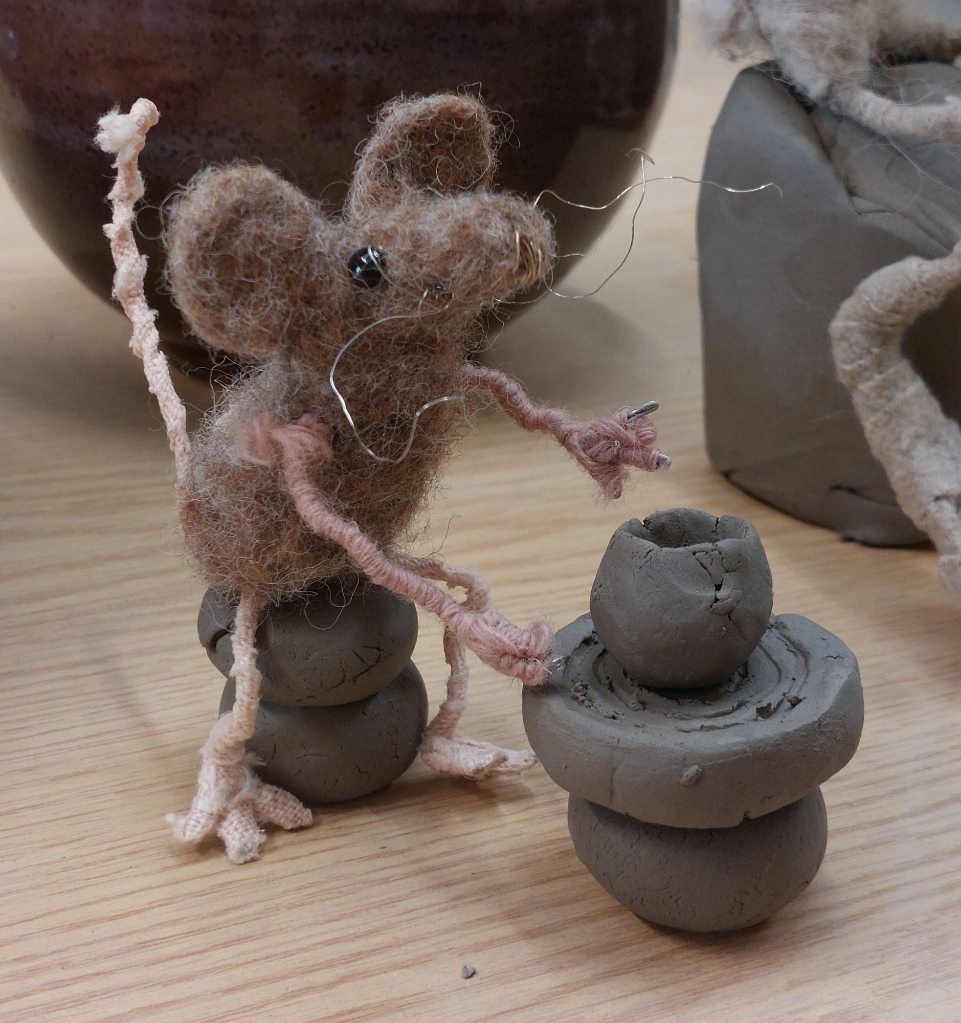 Felted mouse sits at tiny pottery wheel