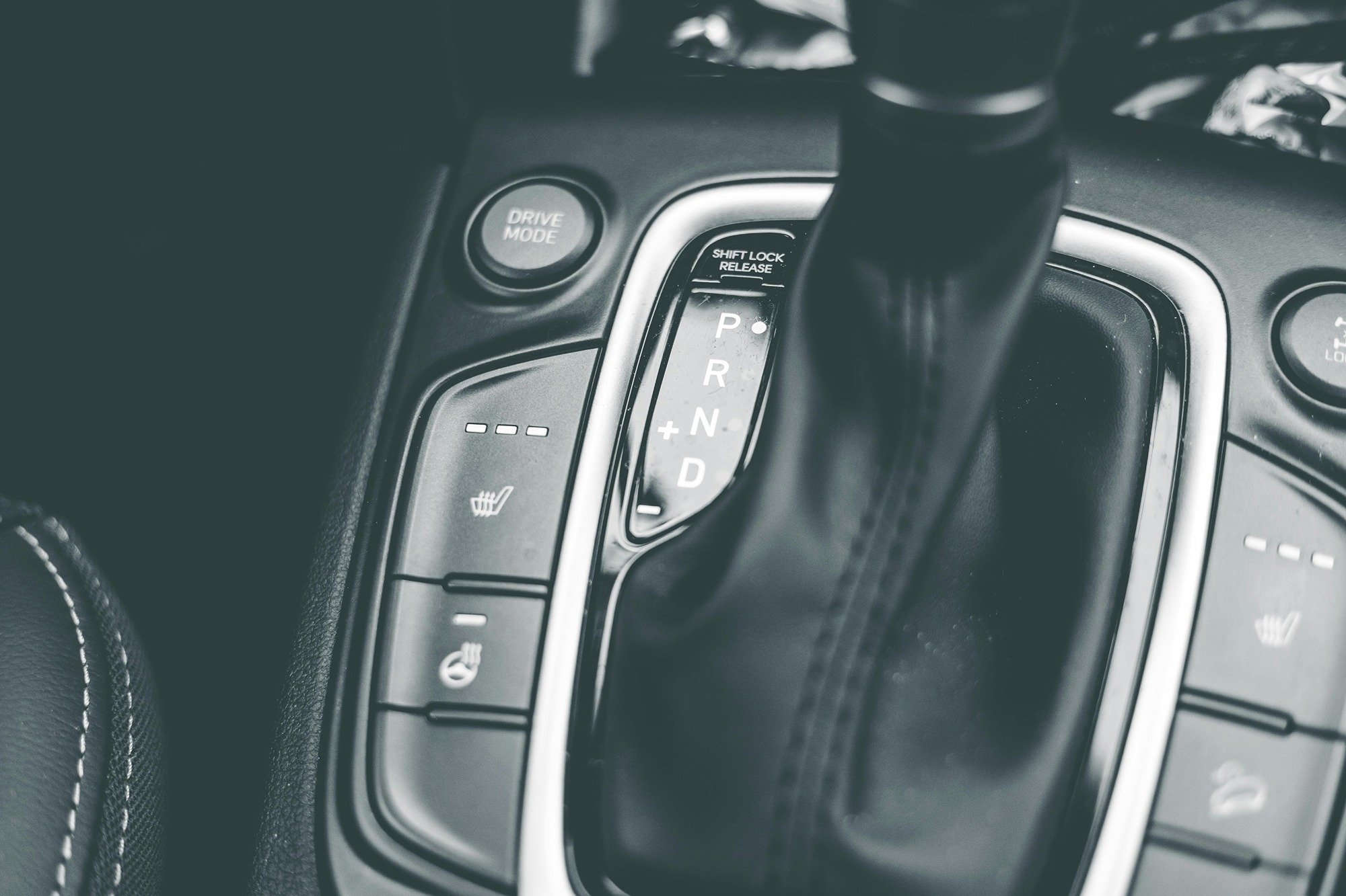 Close-up of a car's automatic gear shift and drive mode button