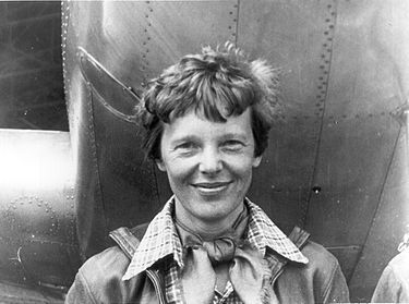 Amelia_Earhart_standing_under_nose_of_her_Lockheed_Model_10-E_Electra,_smal