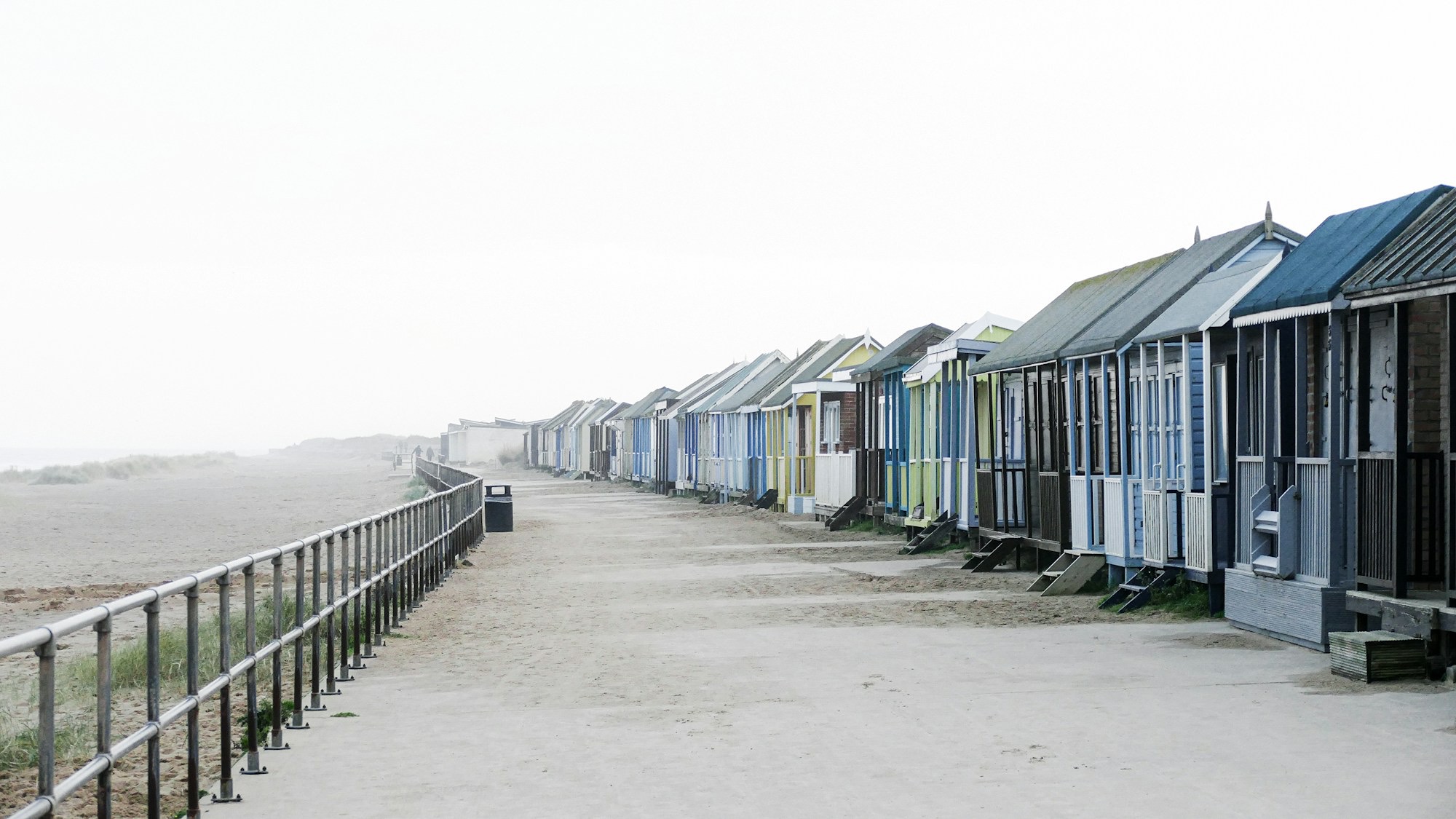a-row-of-houses-on-a-beach-yUQO9rRE5jU