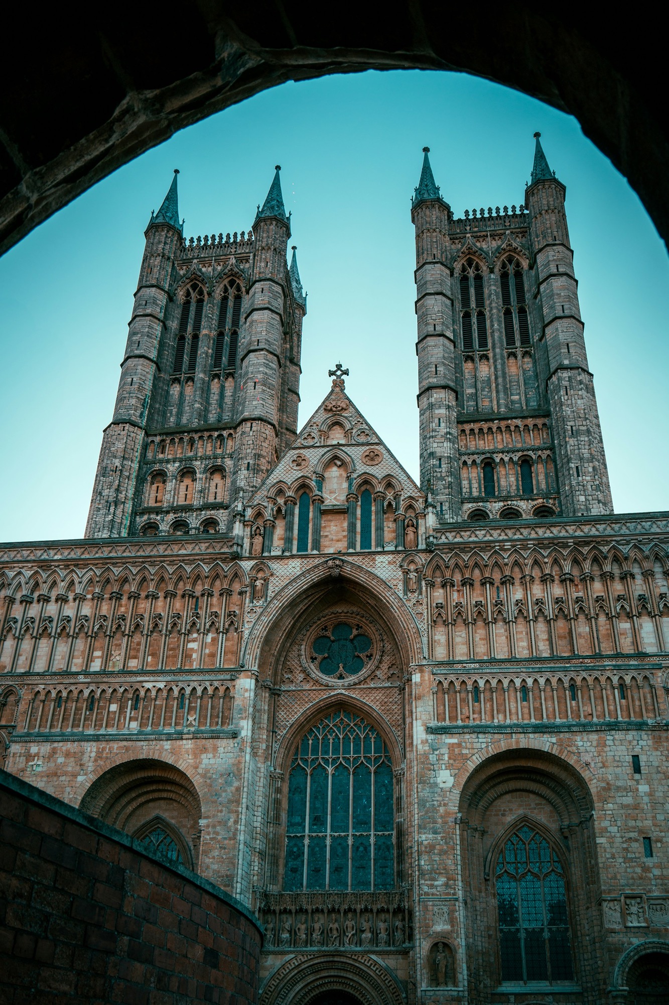 a-view-of-a-cathedral-through-an-arch-rEb55bEP5L0