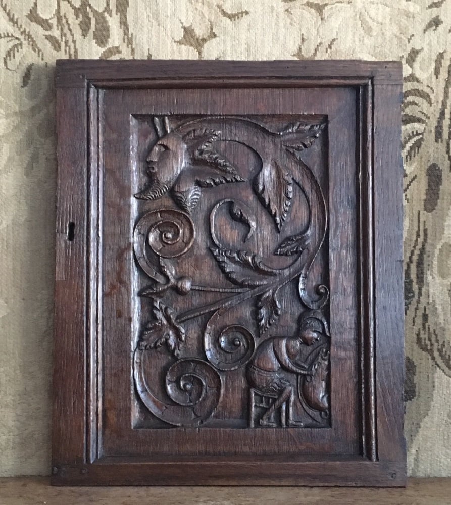 A Folky 17th Century Carved Oak Panel Depicting The Greenman And A Man Seated Butchering A Pig SOLD