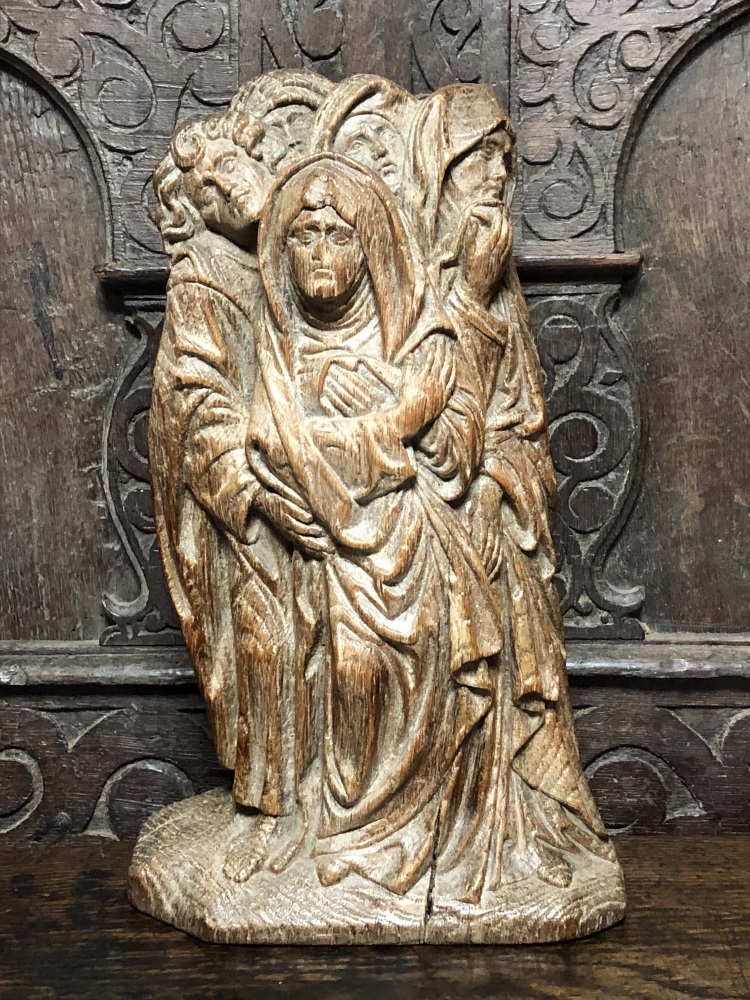 An Early 16th Century Carved Oak Group From The Crucifixion Depicting The Virgin Mary Being Held By St.John And The Three Holy Women.