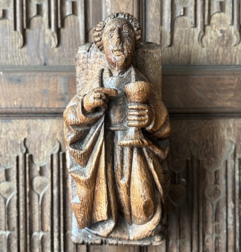 A 16th Century Carved Oak Corbel Depicting St.John Holding A Chalice