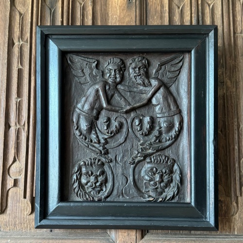 A 16th Century Carved Oak Panel Depicting Angels and Lion Heads.