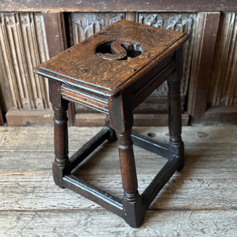 A Rare Charles II oak joint stool with an unusual pierced seat.