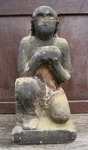 Medieval carved stone figure depicting a naked crouching soul