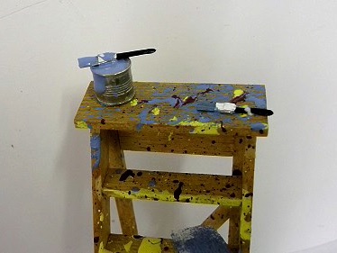 A 12th scale ladder with paint and paint brushes