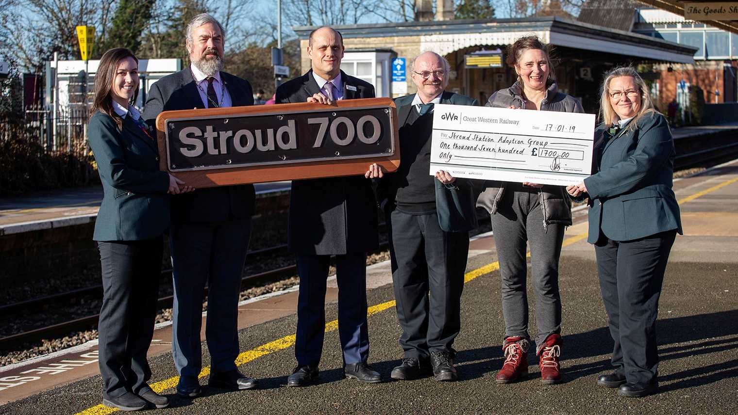 Dignitaries pose for photograph with Stroud 700 nameplate and cheque