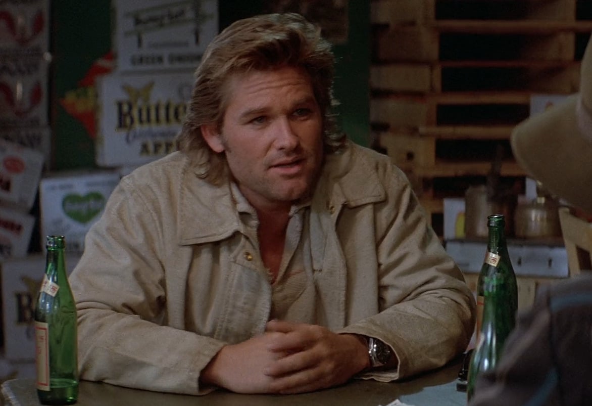 Image shows Jack Burton sitting at a table, looking frustrated after a gambling game