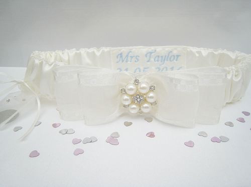 Ivory wedding garter which has been personalised with a blue thread