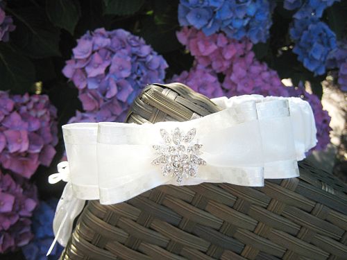 Wedding garter made from satin with a silver sixpence stitched to the side