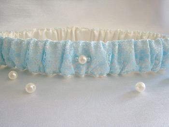 Blue wedding garter which has pearls stitched on it.
