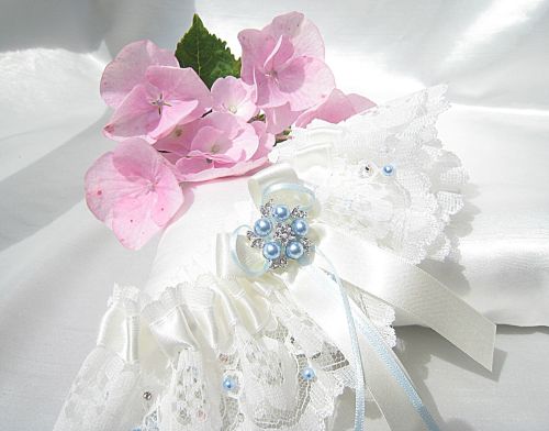 picture of a bridal garter with stitched on Swarovski pearls and crystals, with bows.
