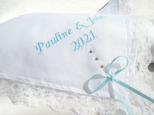Wedding handkerchief showing blue embroidery of the bride and grooms names and the wedding date.