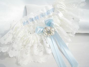 A lace wedding garter which has been personalised on the inside of the garter, with tied ribbon blue bows.