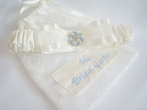 Wedding Garter & Dust Bag Which Has Been Personalised In A Dusty Blue Embroidery Thread.