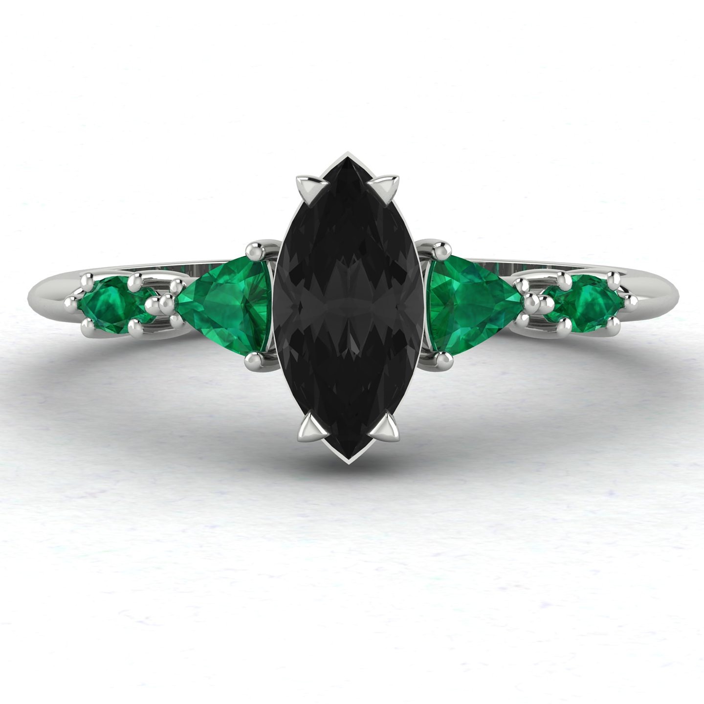Marquise engagement ring featuring the striking combination of black diamonds and green emeralds.