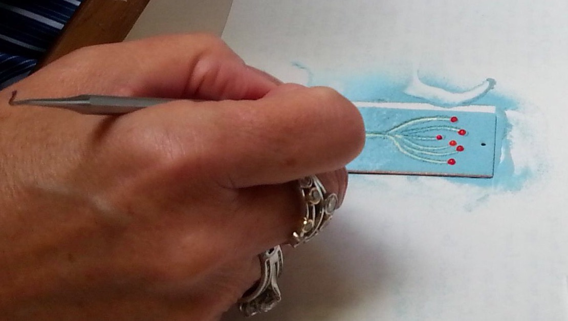 A student creates a design at enamelling session