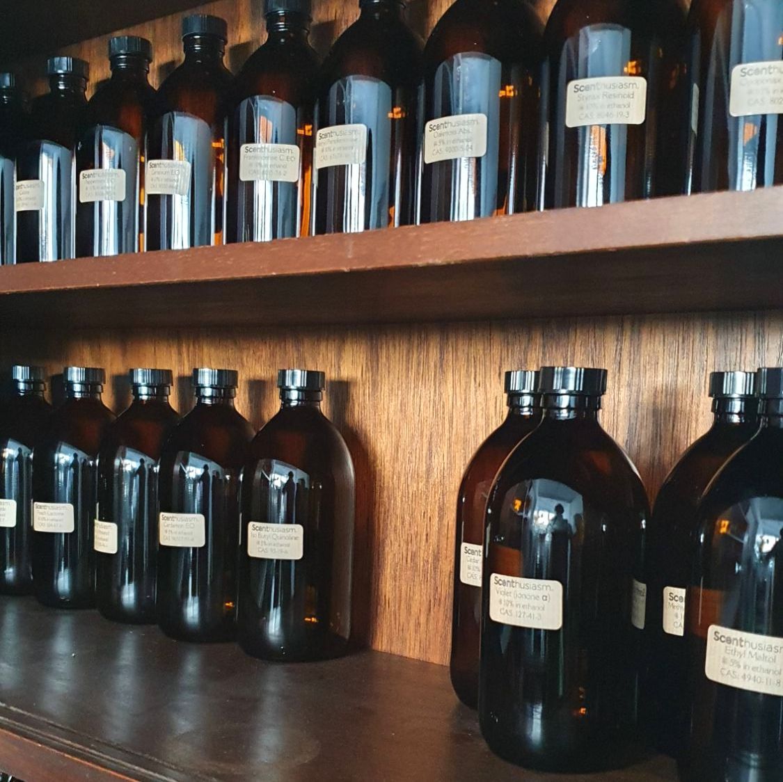 A shelf containing a number of dark brown bottles