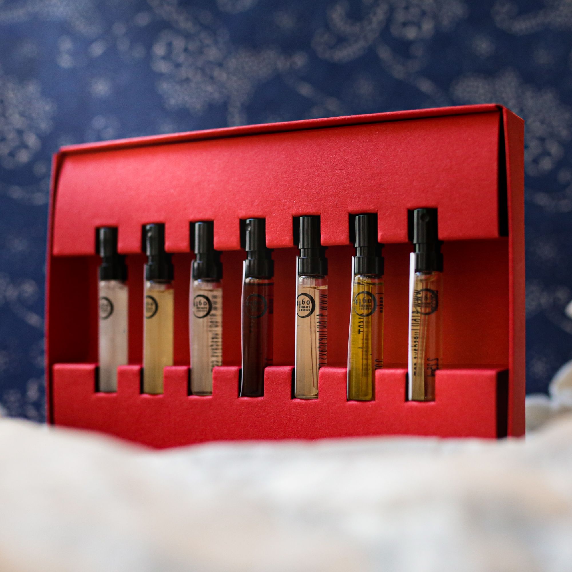 A bottle of 4160 Tuesdays perfume against a purple backdrop