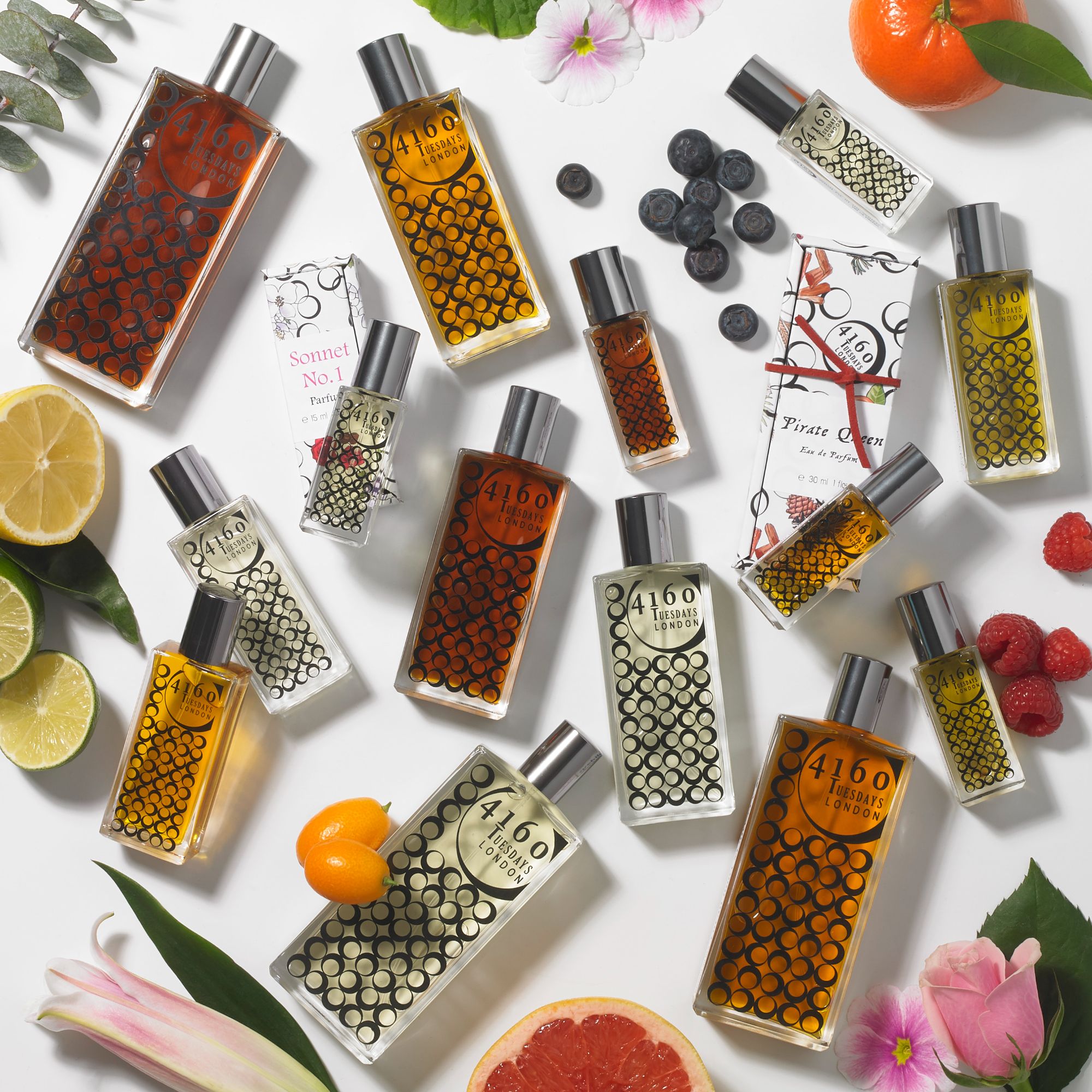 Stylised photo of a bottle of 4160 Tuesdays perfume surrounded by oranges, lemons and limes