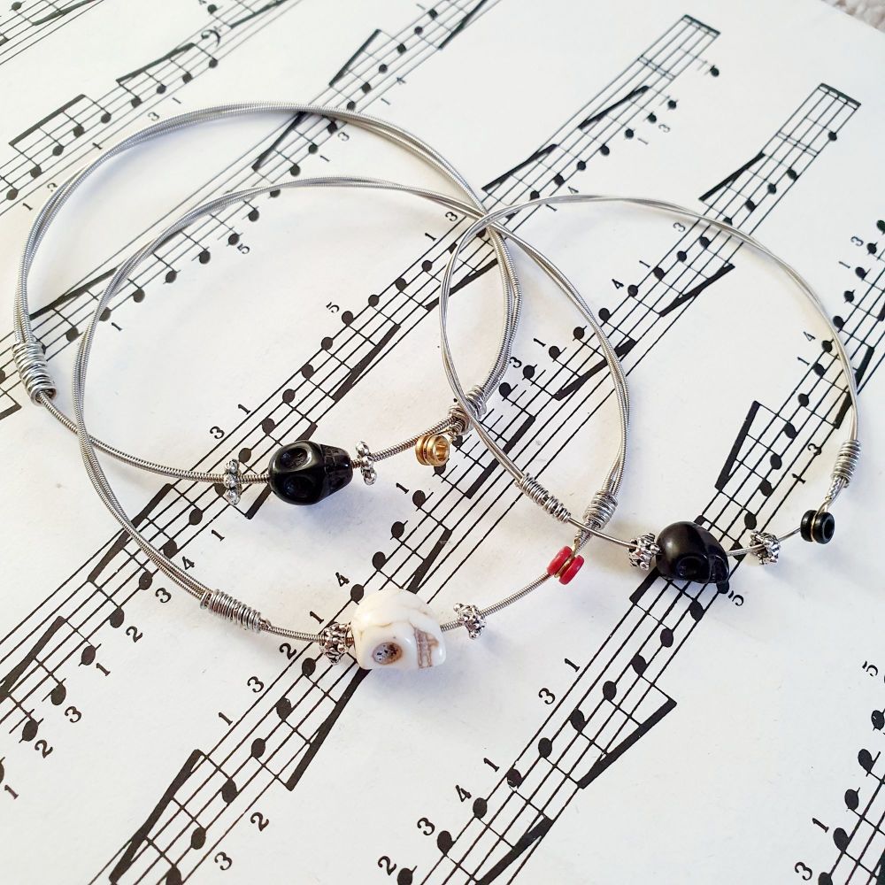 Guitar string bracelet with black or white skull bead on wound string with 
