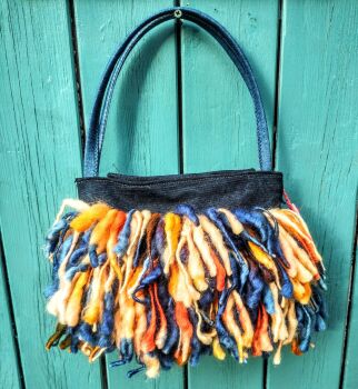 DELILAH : Doogle bag in deadstock designer denim. Fully lined with pockets. Placket closure with magnetic clasps. . Removable mohair corsage. Comforta