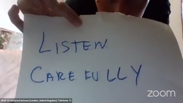 A hand holds a hnadwritten note which reads 'Listen Carefully' 