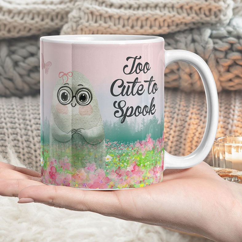 Personalised Too Cute to Spook Pink Halloween Mug | Pinkoween - feminine pastel pink mug featuring a friendly ghost with a bow in a field of pretty flowers